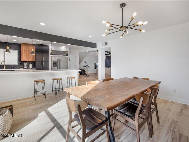 dining space featuring sink and light hardwood / wood-style flooring