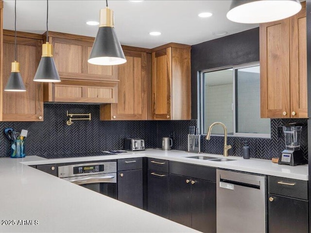 kitchen featuring stainless steel appliances, sink, decorative light fixtures, and decorative backsplash