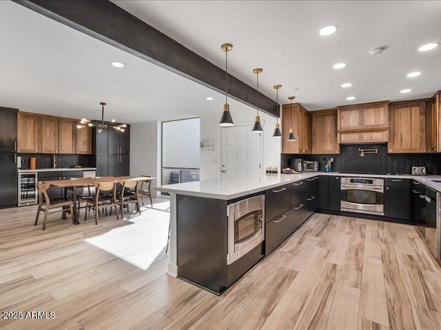 kitchen featuring premium range hood, beverage cooler, stainless steel appliances, beam ceiling, and light hardwood / wood-style floors