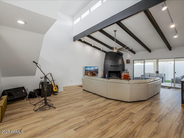 living room with a fireplace, light hardwood / wood-style flooring, lofted ceiling with beams, and ceiling fan