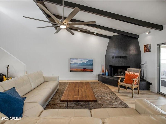 living room featuring a fireplace, lofted ceiling with beams, light hardwood / wood-style floors, and ceiling fan