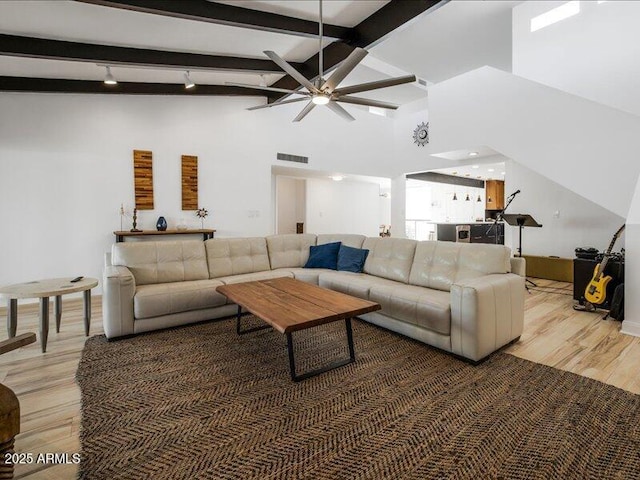 living room with beamed ceiling, ceiling fan, high vaulted ceiling, and hardwood / wood-style floors