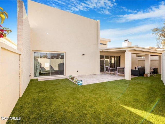 rear view of property with an outdoor living space, a patio area, and a lawn