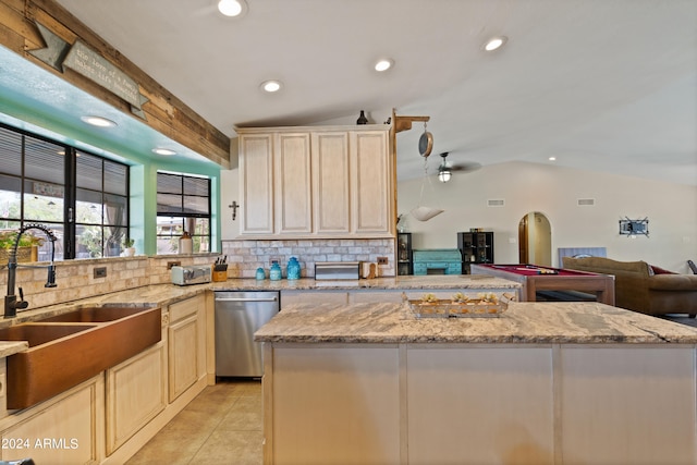 kitchen featuring ceiling fan, lofted ceiling, sink, dishwasher, and light stone countertops