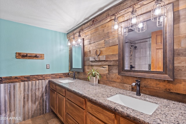 bathroom featuring wooden walls, tile patterned floors, vanity, and tiled shower