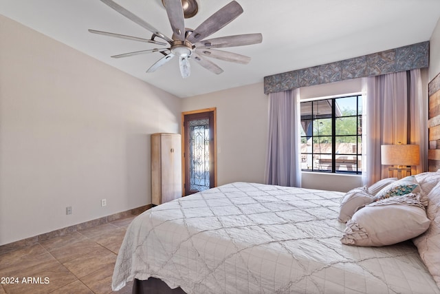 tiled bedroom featuring ceiling fan