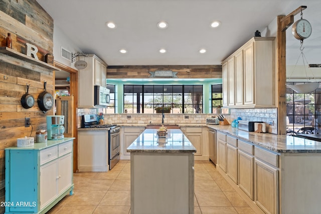 kitchen featuring sink, kitchen peninsula, a kitchen island, stainless steel appliances, and backsplash