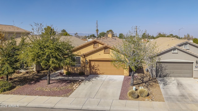 view of property hidden behind natural elements with driveway, a garage, and stucco siding