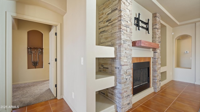 hall featuring carpet flooring and tile patterned floors