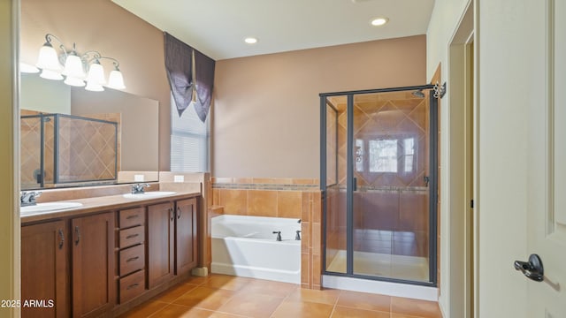 full bath with double vanity, a stall shower, tile patterned floors, a garden tub, and a sink