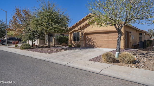 view of front of house with a garage, driveway, central AC unit, and stucco siding