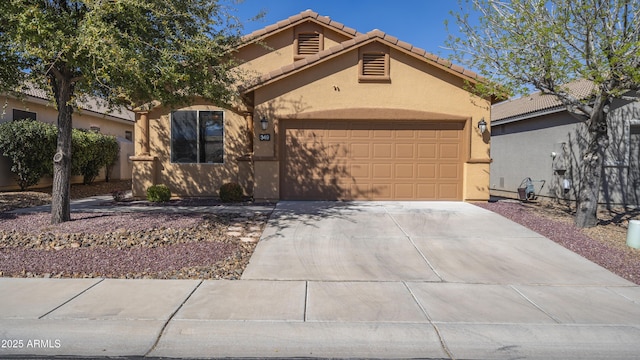 view of front facade with driveway, an attached garage, a tiled roof, and stucco siding