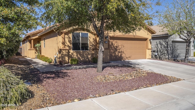 view of front of house with an attached garage, concrete driveway, and stucco siding