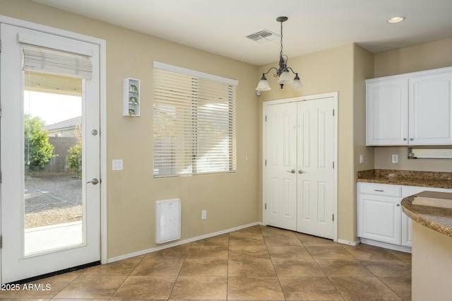 kitchen featuring decorative light fixtures, a chandelier, white cabinets, and light tile patterned flooring