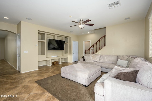 living room featuring built in features and ceiling fan