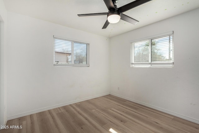 spare room featuring ceiling fan, a healthy amount of sunlight, and light hardwood / wood-style floors