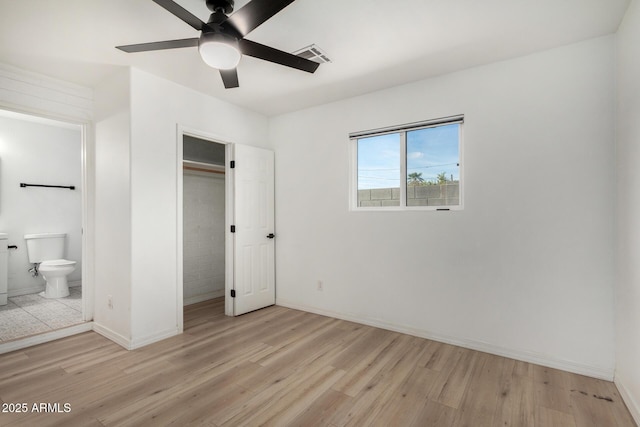 unfurnished bedroom featuring ceiling fan, ensuite bath, a closet, and light hardwood / wood-style flooring