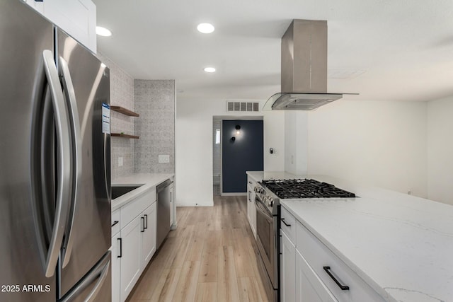 kitchen featuring white cabinetry, light stone countertops, stainless steel appliances, and island exhaust hood