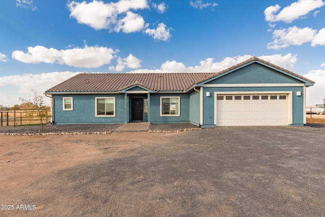 ranch-style house with a garage, driveway, a tile roof, and fence