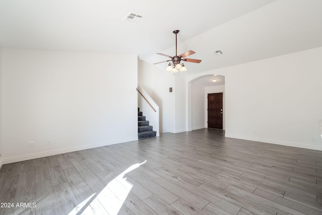 unfurnished living room featuring light wood-type flooring, vaulted ceiling, and ceiling fan