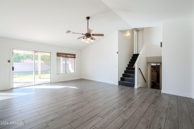 spare room with ceiling fan, light wood-type flooring, and vaulted ceiling