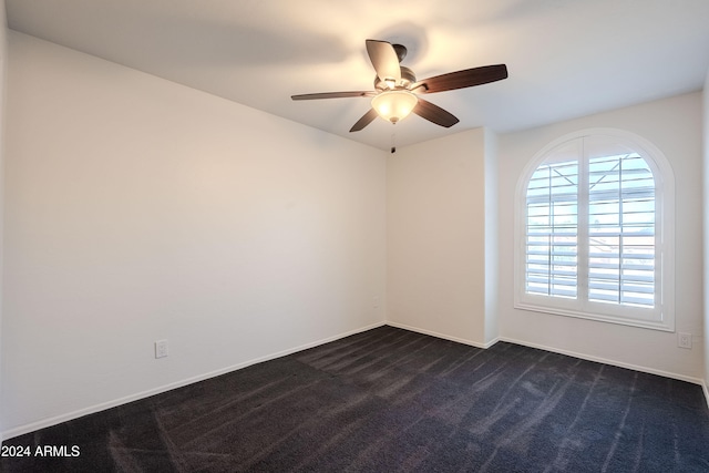 unfurnished room featuring ceiling fan and dark carpet