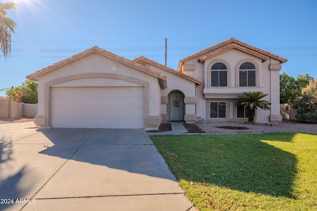 mediterranean / spanish-style house with a garage and a front lawn