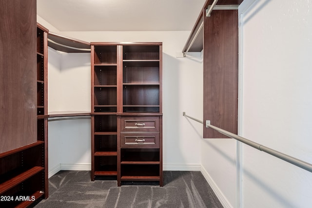 walk in closet featuring dark colored carpet