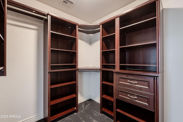 spacious closet with dark carpet