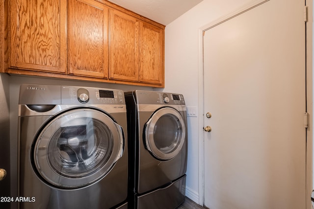 laundry room with cabinets and washing machine and clothes dryer