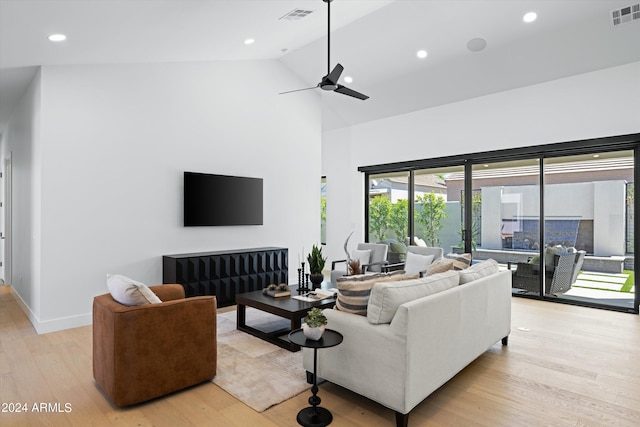 living room with ceiling fan, high vaulted ceiling, and light hardwood / wood-style flooring