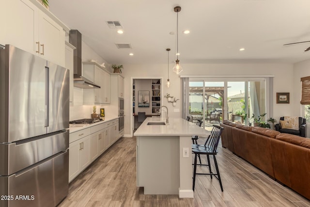 10447 W Salter Dr, Peoria, AZ 85382 - kitchen featuring stainless steel appliances, a sink, wall chimney exhaust hood, open floor plan, and light countertops