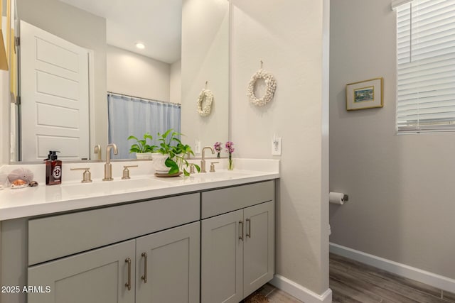10447 W Salter Dr, Peoria, AZ 85382 - full bathroom with double vanity, wood finished floors, baseboards, and recessed lighting