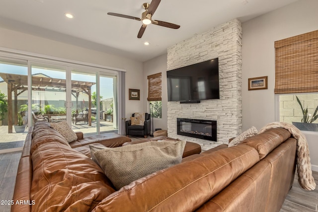 10447 W Salter Dr, Peoria, AZ 85382 - living room with wood finished floors, a ceiling fan, a stone fireplace, and recessed lighting
