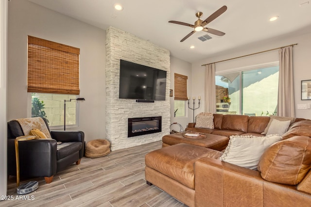 10447 W Salter Dr, Peoria, AZ 85382 - living area featuring ceiling fan, plenty of natural light, light wood-type flooring, a stone fireplace, and recessed lighting