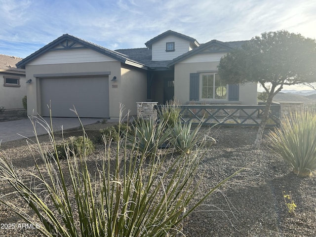 view of front facade with a garage, driveway, and stucco siding