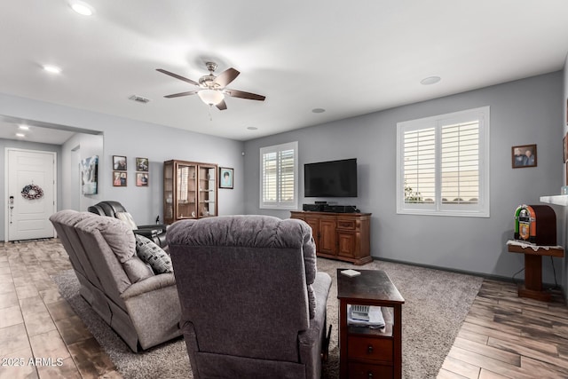 living area with recessed lighting, visible vents, a ceiling fan, wood finished floors, and baseboards