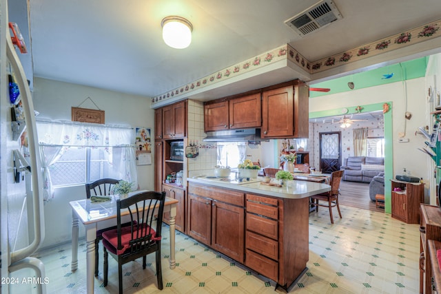 kitchen featuring ceiling fan, white gas stovetop, and tasteful backsplash