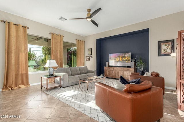 living area featuring ceiling fan, light tile patterned flooring, visible vents, and baseboards