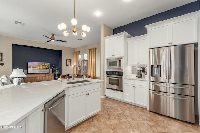 kitchen featuring tasteful backsplash, visible vents, white cabinets, appliances with stainless steel finishes, and a sink