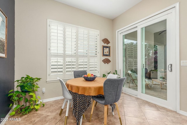 tiled dining area featuring baseboards