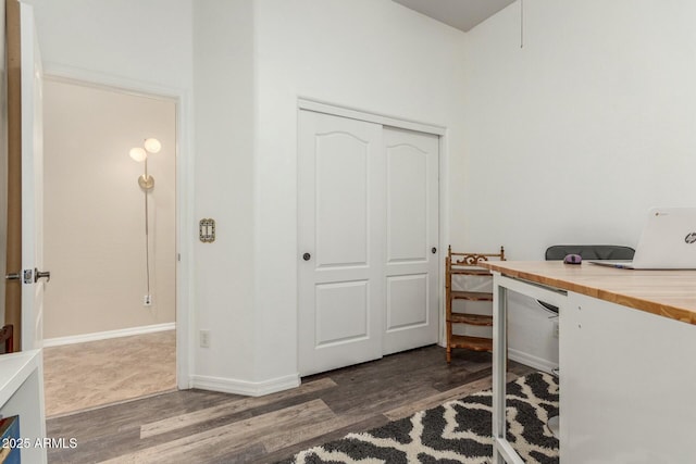 home office with baseboards and wood finished floors