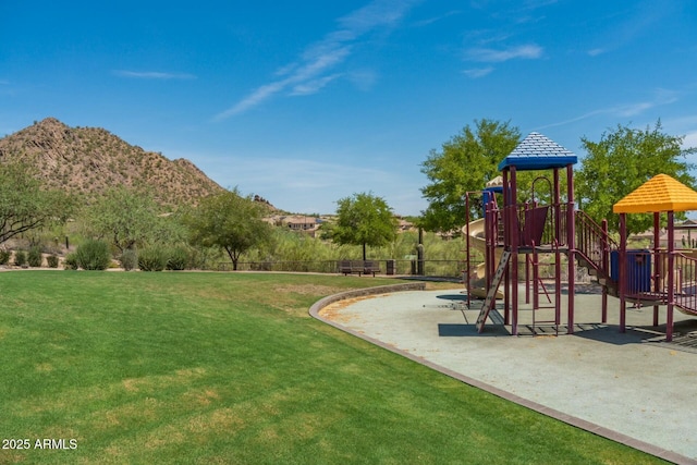 communal playground featuring a mountain view and a yard