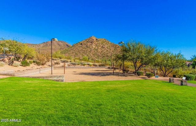 view of home's community with a mountain view and a lawn