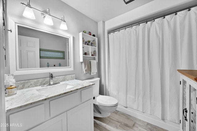 full bathroom with vanity, shower / bath combo with shower curtain, and toilet