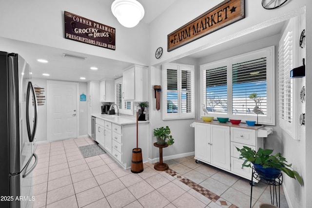 kitchen with white cabinetry, stainless steel appliances, sink, and light tile patterned floors