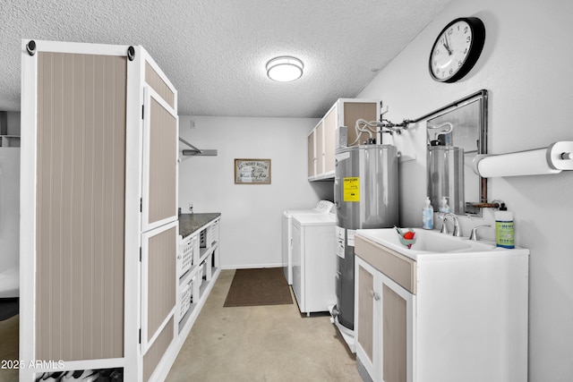 laundry room featuring water heater, electric water heater, cabinets, a textured ceiling, and washing machine and clothes dryer