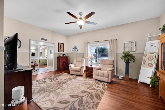 living area with dark hardwood / wood-style flooring and ceiling fan