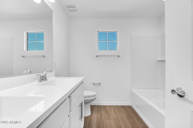 full bath featuring toilet, wood finish floors, visible vents, vanity, and baseboards