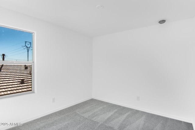 unfurnished room featuring carpet flooring and baseboards